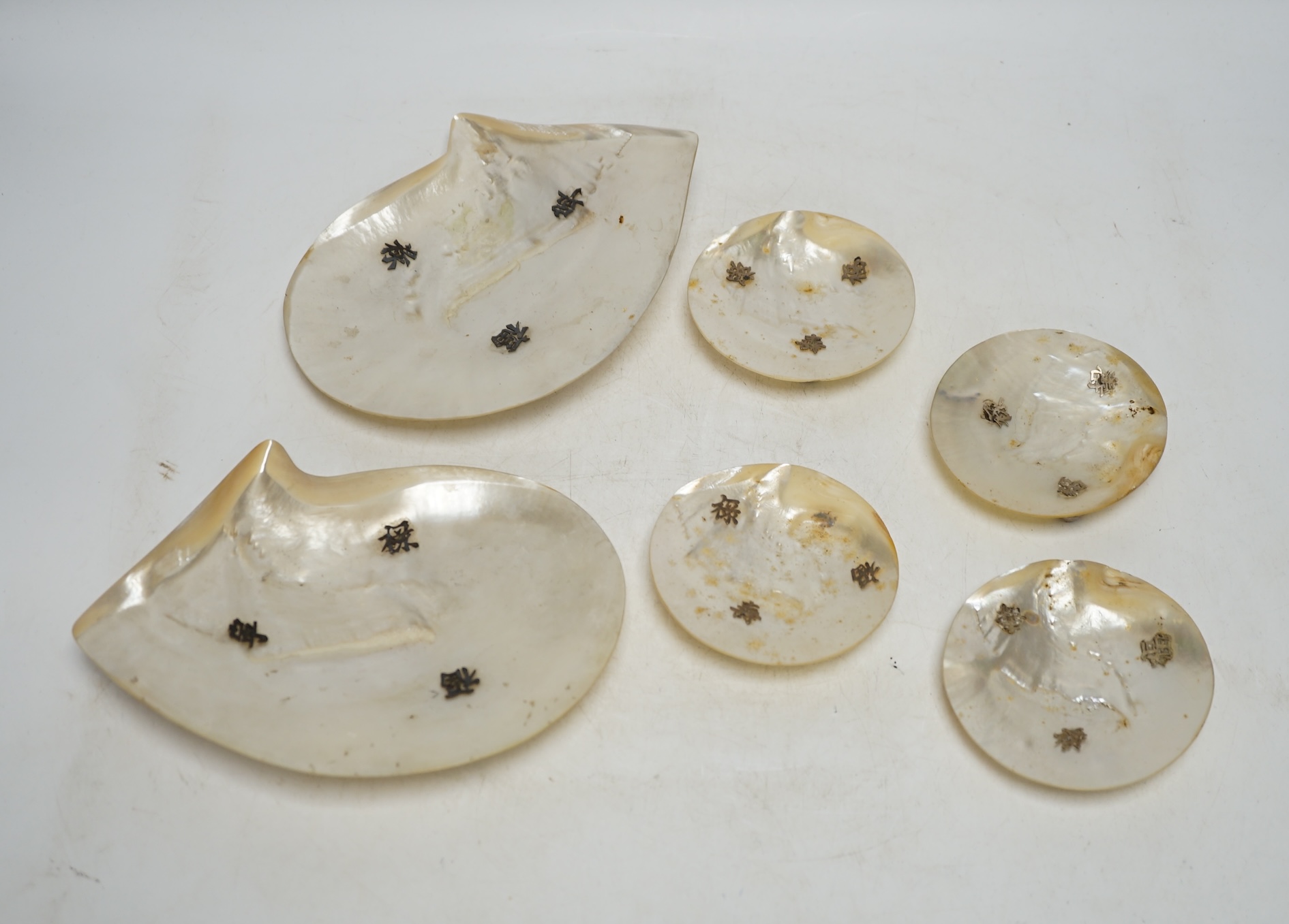 Six Chinese mother-of-pearl dishes on metal ball feet, largest 17.5cm wide. Condition - two ball feet missing on both larger shell dishes